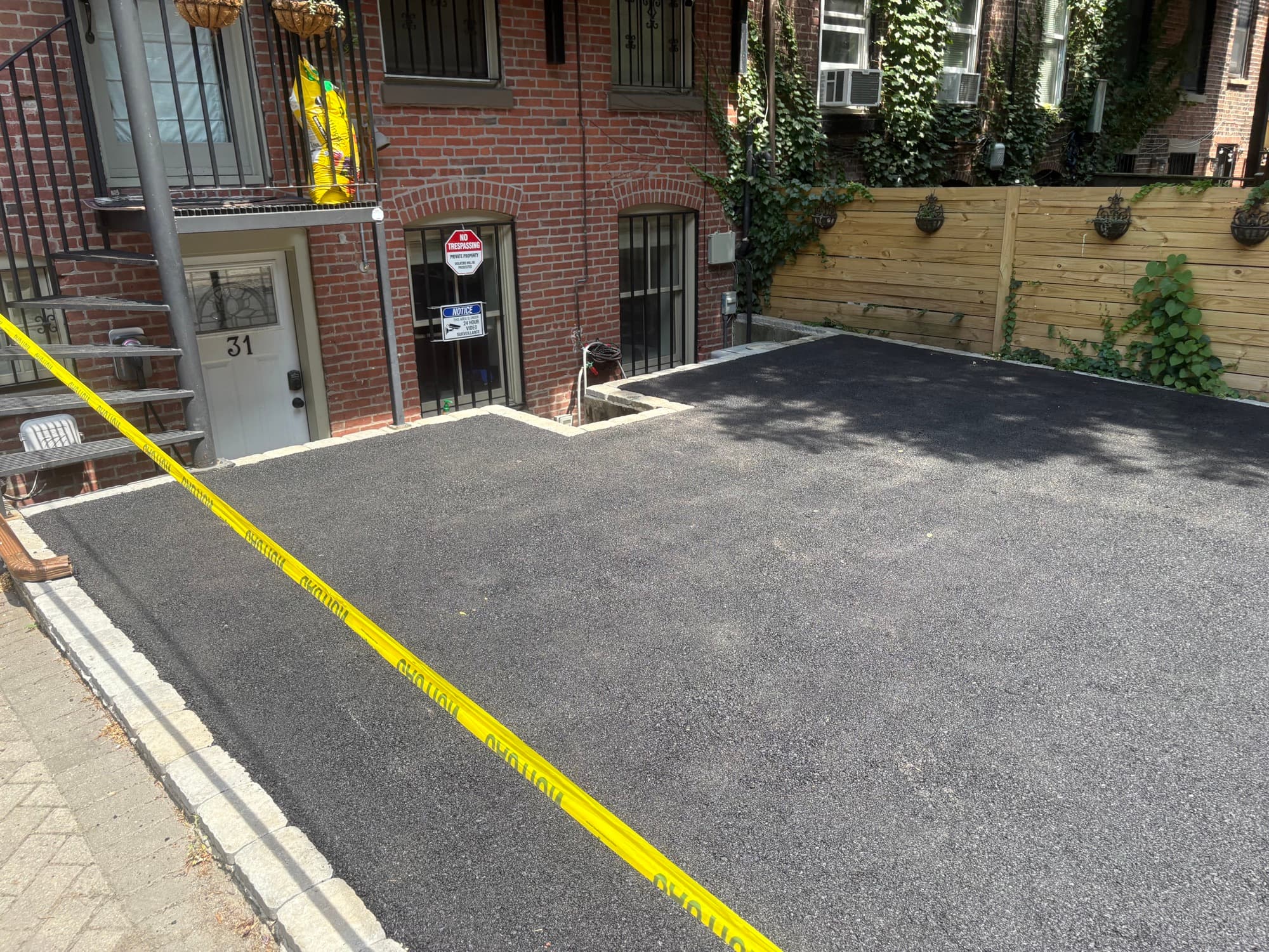 Fresh asphalt driveway with granite cobblestone edging